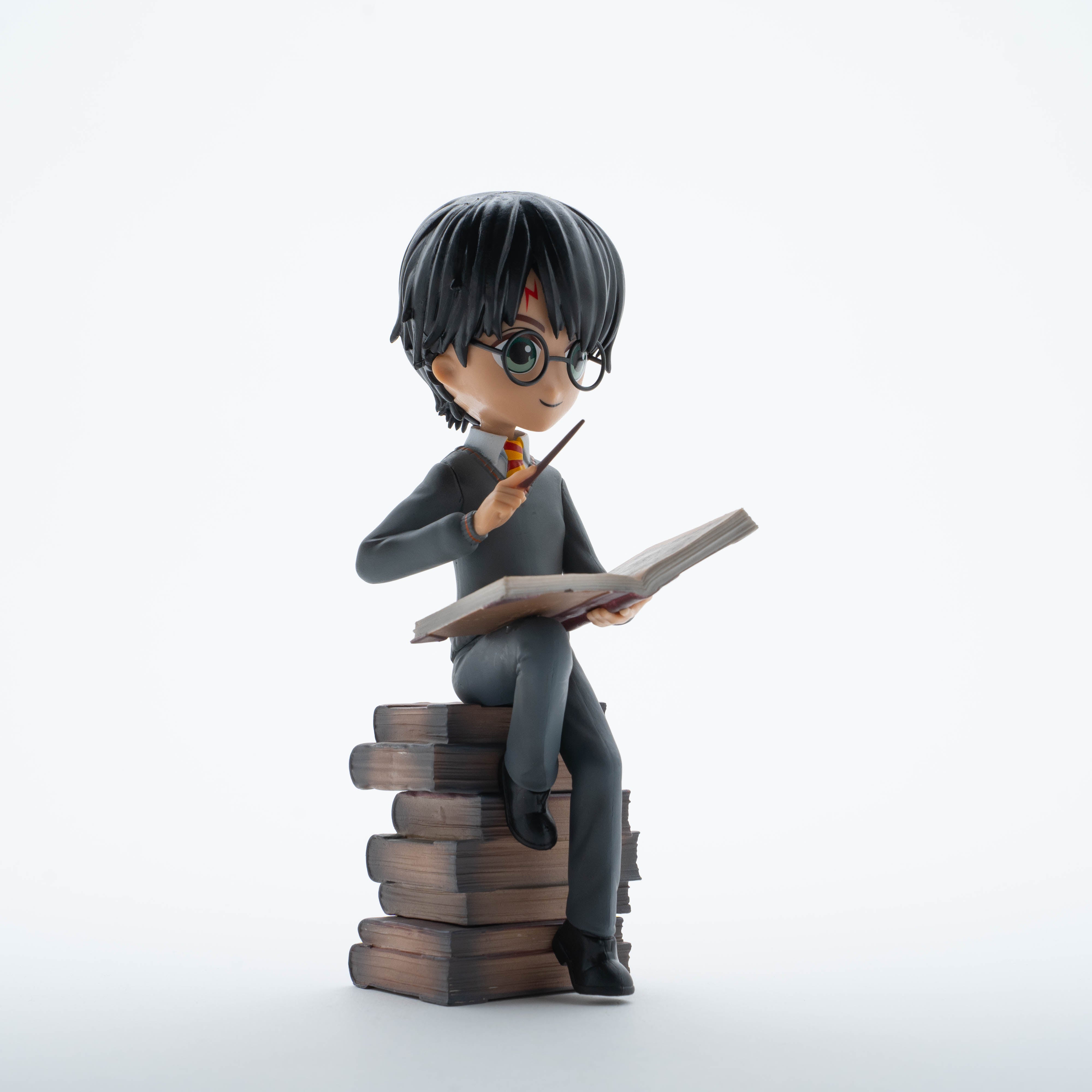 Figurine Harry Potter sur une pile de Grimoires - Boutique Harry Potter